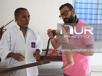 Workers examine a new prosthetic limb inside the Rehabilitation & Research Centre, a unit of Mahavir Seva Sadan, in Arambag on the outskirts...