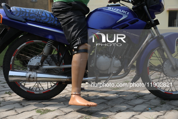 An amputee with a prosthetic limb rides a motorcycle outside the Rehabilitation & Research Centre, a unit of Mahavir Seva Sadan, in Arambag...