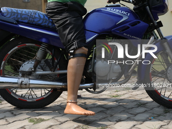 An amputee with a prosthetic limb rides a motorcycle outside the Rehabilitation & Research Centre, a unit of Mahavir Seva Sadan, in Arambag...