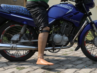 An amputee with a prosthetic limb rides a motorcycle outside the Rehabilitation & Research Centre, a unit of Mahavir Seva Sadan, in Arambag...