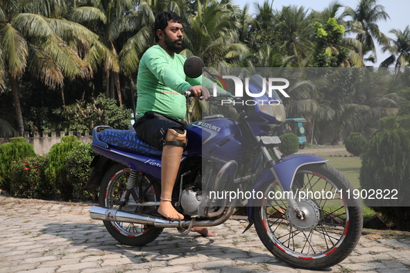 An amputee with a prosthetic limb rides a motorcycle outside the Rehabilitation & Research Centre, a unit of Mahavir Seva Sadan, in Arambag...