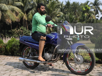 An amputee with a prosthetic limb rides a motorcycle outside the Rehabilitation & Research Centre, a unit of Mahavir Seva Sadan, in Arambag...