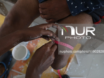 A worker takes measurements before manufacturing a prosthetic limb inside the Rehabilitation & Research Centre, a unit of Mahavir Seva Sadan...