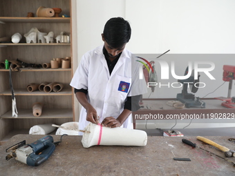 A worker measures a limb prosthetic inside the Rehabilitation & Research Centre, a unit of Mahavir Seva Sadan, in Arambag on the outskirts o...