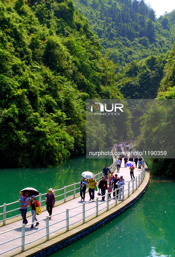 Tourists walk on a 500-meter-long plank road built over the river in Xuan'en County, central China's Hubei Province, May 1, 2016.