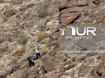 A rescue team climbs a hill to recover the body of the immigration officer who loses his life during an attack with rocks thrown by migrants...