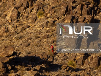 A rescue team climbs a hill to recover the body of the immigration officer who loses his life during an attack with rocks thrown by migrants...