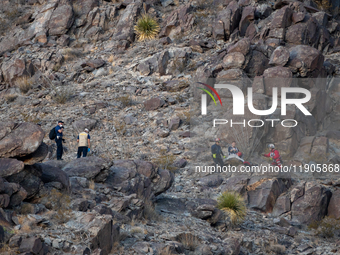 A rescue team climbs a hill to recover the body of the immigration officer who loses his life during an attack with rocks thrown by migrants...