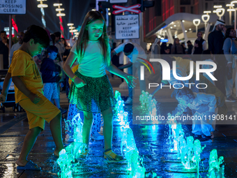 Children play in the water during New Year's Day celebrations at Lusail Boulevard in Doha, Qatar, on January 1, 2025. (