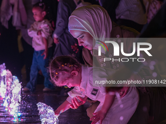 Children play in the water during New Year's Day celebrations at Lusail Boulevard in Doha, Qatar, on January 1, 2025. (