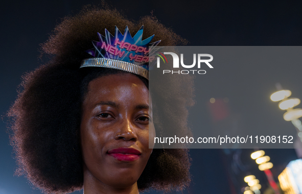 A woman wears a New Year's headband during New Year's Day celebrations at Lusail Boulevard in Doha, Qatar, on January 1, 2025. 