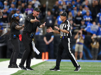 DETROIT,MICHIGAN-JANUARY 5:  Head coach Dan Campbell of the Detroit Lions interacts with down judge Kent Payne (79) during a game between th...