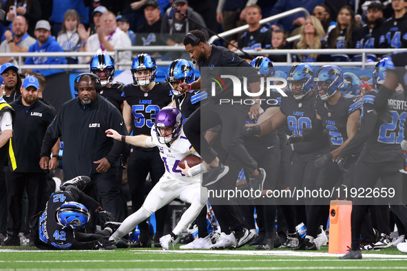 DETROIT,MICHIGAN-JANUARY 5:  Quarterback Sam Darnold (14) of the Minnesota Vikings runs the ball as Detroit Lions staff leaps to avoid a col...