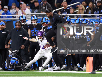 DETROIT,MICHIGAN-JANUARY 5:  Quarterback Sam Darnold (14) of the Minnesota Vikings runs the ball as Detroit Lions staff leaps to avoid a col...