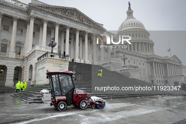 A crew clears snow from the plaza and steps at the United States Capitol on the anniversary of the January 6, 2021, insurrection in Washingt...