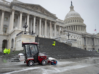 A crew clears snow from the plaza and steps at the United States Capitol on the anniversary of the January 6, 2021, insurrection in Washingt...