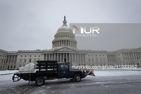 Workers clear snow from the plaza and steps at the United States Capitol on the anniversary of the January 6, 2021, insurrection in Washingt...