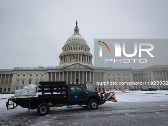 Workers clear snow from the plaza and steps at the United States Capitol on the anniversary of the January 6, 2021, insurrection in Washingt...