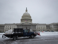 Workers clear snow from the plaza and steps at the United States Capitol on the anniversary of the January 6, 2021, insurrection in Washingt...