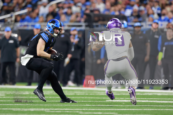 DETROIT,MICHIGAN-JANUARY 5:  Tight end Sam LaPorta (87) of the Detroit Lions carries the ball under the pressure of linebacker Ivan Pace Jr....