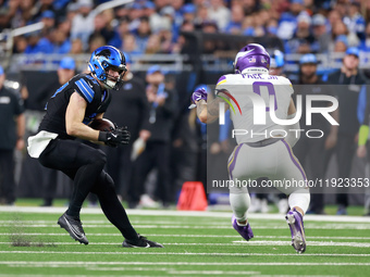 DETROIT,MICHIGAN-JANUARY 5:  Tight end Sam LaPorta (87) of the Detroit Lions carries the ball under the pressure of linebacker Ivan Pace Jr....