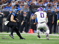 DETROIT,MICHIGAN-JANUARY 5:  Tight end Sam LaPorta (87) of the Detroit Lions carries the ball under the pressure of linebacker Ivan Pace Jr....