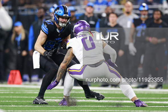 DETROIT,MICHIGAN-JANUARY 5:  Tight end Sam LaPorta (87) of the Detroit Lions carries the ball under the pressure of linebacker Ivan Pace Jr....