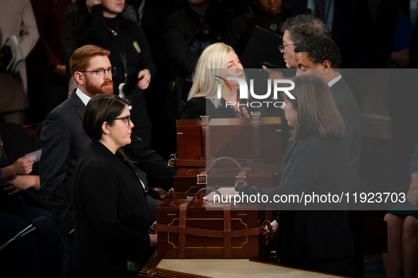 House floor staff close up the boxes containing electoral vote certificates following the conclusion of a oint session of Congress certifyin...