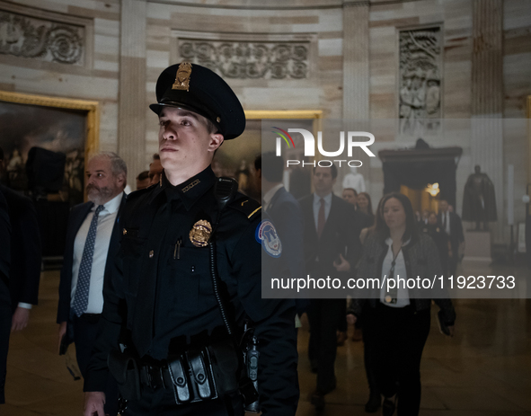 A Capitol Police officer escorts Senators through the Capitol rotunda to a joint session of Congress certifying the results of the 2024 pres...