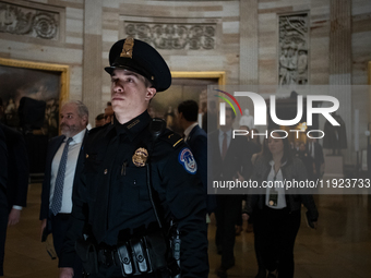 A Capitol Police officer escorts Senators through the Capitol rotunda to a joint session of Congress certifying the results of the 2024 pres...