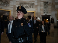 A Capitol Police officer escorts Senators through the Capitol rotunda to a joint session of Congress certifying the results of the 2024 pres...