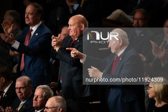 Rep. Mike Kelly (R-PA) (right) and other Republicans applaud the reading of electoral votes for Trump during a joint session of Congress cer...