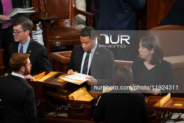 House floor staff distribute electoral vote certificates following the conclusion of a joint session of Congress certifying the results of t...