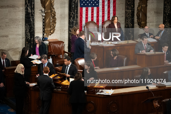 House floor staff (bottom left) distribute electoral vote certificates while Vice President Kamala Harris presides over a joint session of C...