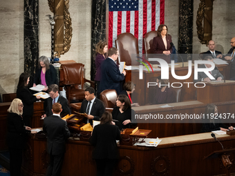 House floor staff (bottom left) distribute electoral vote certificates while Vice President Kamala Harris presides over a joint session of C...