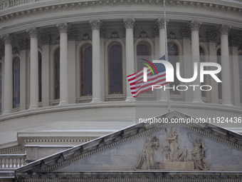 A flag flies at half-staff in honor of President Jimmy Carter, who passed away Dewcember 29, as snow falls on the Capitol on the anniversary...