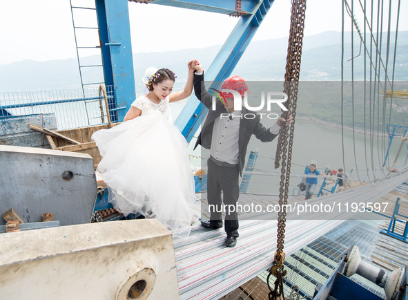 Young couples walk up to have their wedding photos taken on a suspension bridge over the Yangtze River in southwest China's Chongqing Munici...