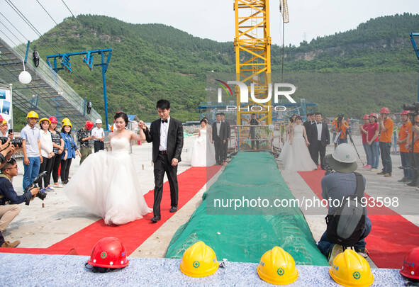 Young couples have their wedding photos taken on a suspension bridge over the Yangtze River in southwest China's Chongqing Municipality, May...