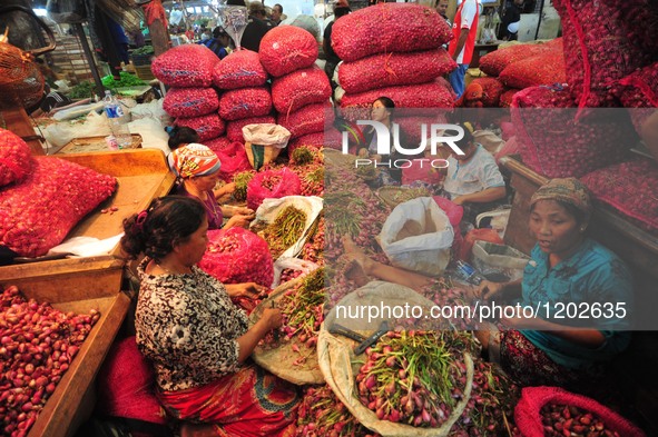 Indonesian workers sort red onions at a fresh food and vegetable market in Jakarta, Indonesia, May 10, 2016.