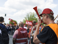 Employees of the Dailmer have gathered for a warning strike rally in front of the entrance to the company's plant in Berlin, Germany, 11 May...