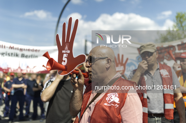 Employees of the Dailmer have gathered for a warning strike rally in front of the entrance to the company's plant in Berlin, Germany, 11 May...