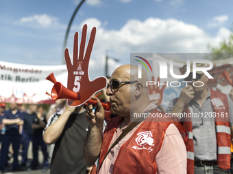 Employees of the Dailmer have gathered for a warning strike rally in front of the entrance to the company's plant in Berlin, Germany, 11 May...