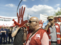 Employees of the Dailmer have gathered for a warning strike rally in front of the entrance to the company's plant in Berlin, Germany, 11 May...