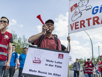 Employees of the Dailmer have gathered for a warning strike rally in front of the entrance to the company's plant in Berlin, Germany, 11 May...