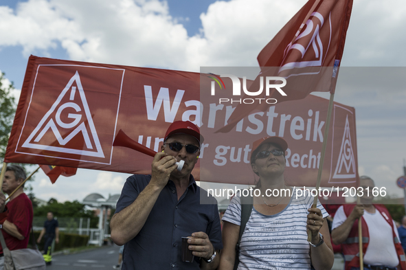 Employees of the Dailmer have gathered for a warning strike rally in front of the entrance to the company's plant in Berlin, Germany, 11 May...