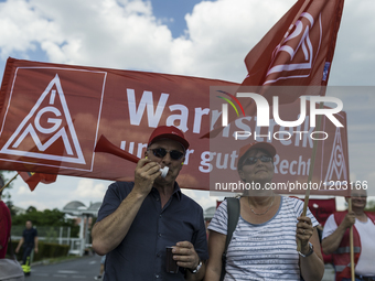 Employees of the Dailmer have gathered for a warning strike rally in front of the entrance to the company's plant in Berlin, Germany, 11 May...