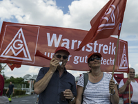 Employees of the Dailmer have gathered for a warning strike rally in front of the entrance to the company's plant in Berlin, Germany, 11 May...