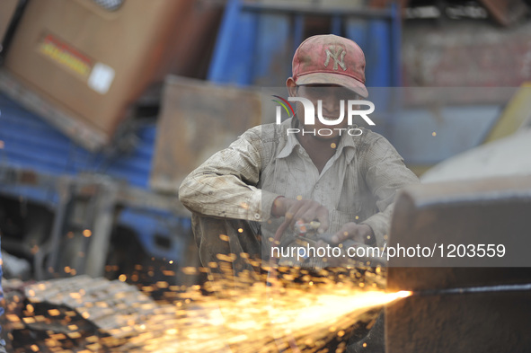 SUDHIR KUMAR PATEL, 28 yrs old, migrated from India smiles as Cutting heavy duty roller's Metal with Oxygen Acetylene Gas as Spark splash ar...