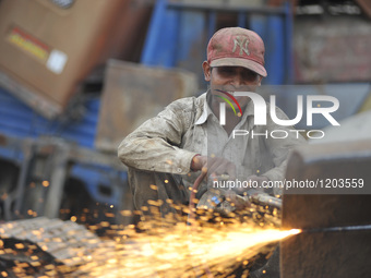 SUDHIR KUMAR PATEL, 28 yrs old, migrated from India smiles as Cutting heavy duty roller's Metal with Oxygen Acetylene Gas as Spark splash ar...