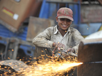 SUDHIR KUMAR PATEL, 28 yrs old, migrated from India smiles as Cutting heavy duty roller's Metal with Oxygen Acetylene Gas as Spark splash ar...